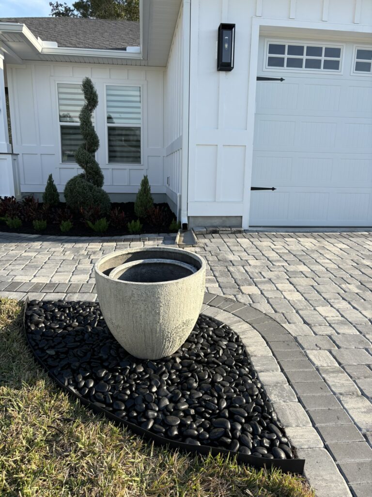 Decorative planter feature with river rock and paver walkway landscape design