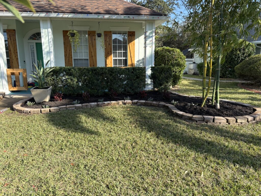 Curved front lawn landscape bed with hedge border and stone edging