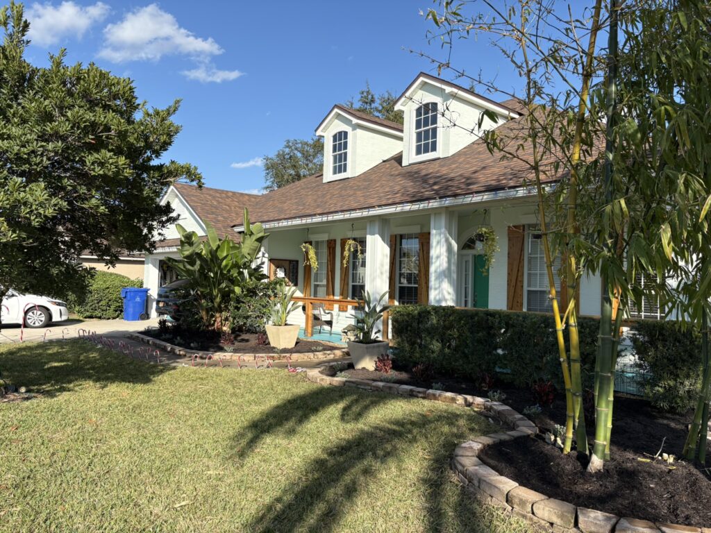 Florida home landscape design with curved garden bed and tropical plantings