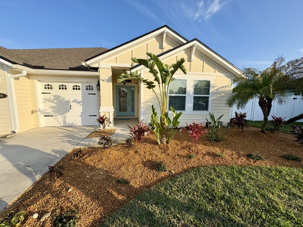 Front yard tropical landscape with banana plant and decorative rock ground cover