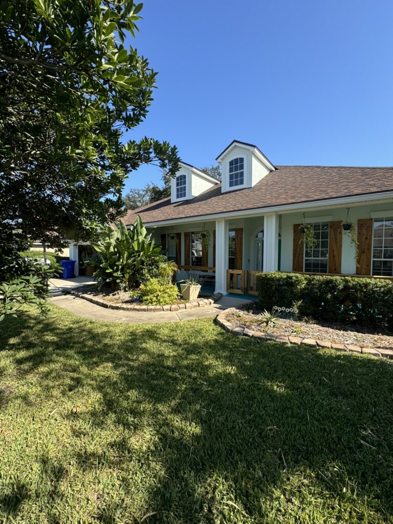 Florida home landscape design with curved garden bed and tropical plants